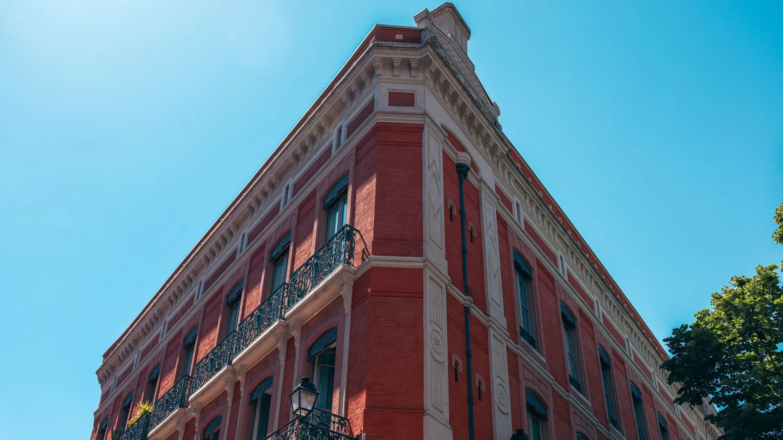Façade de brique rose à Toulouse sous un ciel bleu